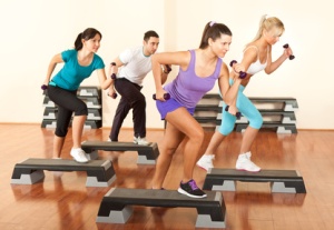 group of people exercising with dumbbells in the fitness club